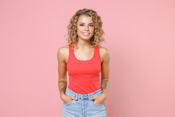 Smiling charming beautiful attractive young blonde woman 20s wearing basic casual tank top standing...