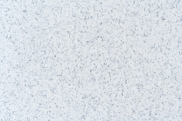 White paper surface with inclusion of blue stripes and spots as texture, background (close up, macro)
