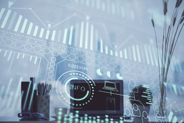 Computer on desktop in office with technology theme hologram. Double exposure. Tech concept.