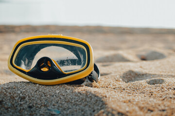 Diving Goggles lying on the sandy beach. snorkel on sandy background. Travel and Summer vacation swimming concept.
