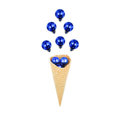 Christmas blue balls above a waffle cone isolated on white background