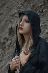 Close-up portrait of a beautiful pensive teen girl in black hood.