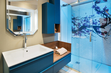 Neat bathroom with blue shower cubicle and vanity