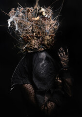 Fototapeta na wymiar woman in black clothes and skull makeup, a crown of dry branches and flowers on her head