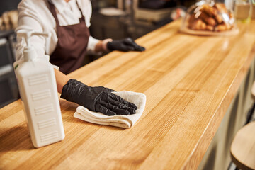 Female waiter in gloves preparing cafe for open