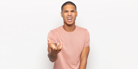 young black man looking angry, annoyed and frustrated screaming wtf or what’s wrong with you