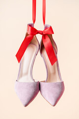 lilac suede heeled shoes with red bow isolated on beige