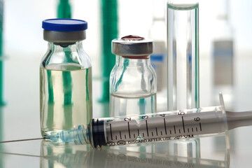 Medicine bottle for injection and syringe with medical vials for vaccination, selective focus