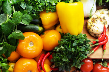 A lot of vegetables and herbs close-up. A pile of tomatoes and peppers on a wooden shelf. Trade in groceries