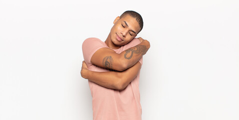 young black man feeling in love, smiling, cuddling and hugging self, staying single, being selfish...