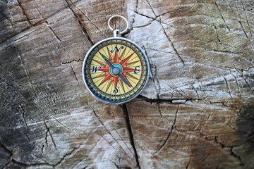 round compass on natural wooden background as symbol of tourism with compass, travel with compass...