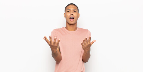 young black man feeling extremely shocked and surprised, anxious and panicking, with a stressed and...