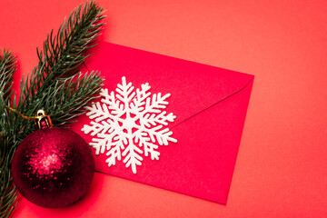 top view of Christmas decoration and envelope on red background