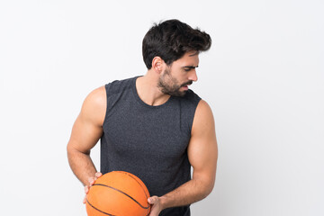 Young handsome man with beard over isolated white background playing basketball