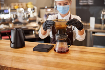 Barista barista pouring manual drip brewer to make coffee