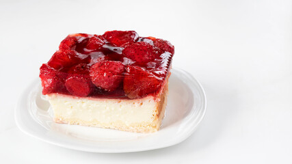Cheesecake with strawberry jelly and strawberries on a plate.