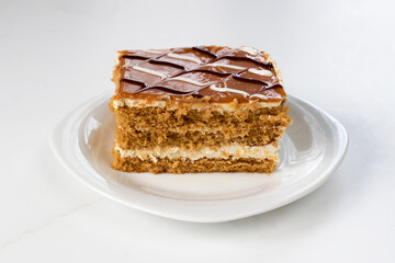 Honey cake with butter cream on a plate.