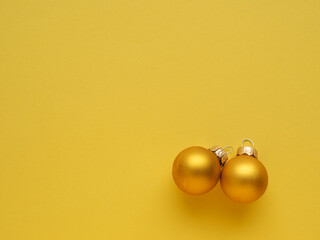Golden vintage Christmas baubles on a yellow background with space for text or image, seasonal...