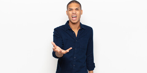 young black man looking angry, annoyed and frustrated screaming wtf or what’s wrong with you
