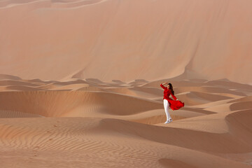 Fototapeta na wymiar Girl in a red dress in the desert.