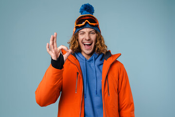 Young excited sportsman winking and showing ok sign