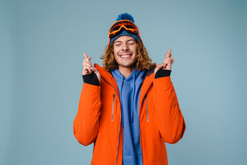Young excited sportsman posing with fingers crossed for good luck