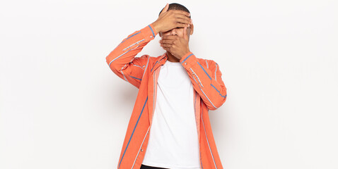 young black man covering face with both hands saying no to the camera! refusing pictures or...