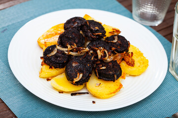 Spanish blood sausage morcilla served with potato and onion