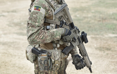 Soldier with assault rifle and flag of Ethiopia on military uniform. Collage.