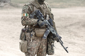 Soldier with assault rifle and flag of Ivory Coast or Cote d'Ivoire on military uniform. Collage.