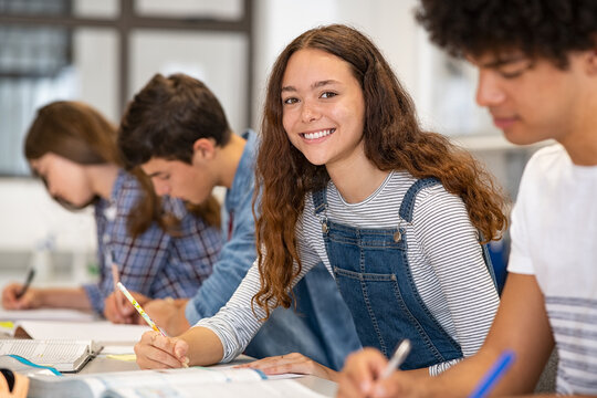 Portrait of happy high school girl studying in class