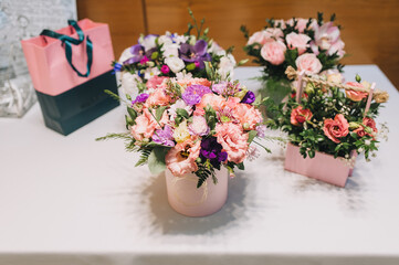 Multicolored fresh flowers stand in paper and wooden box, basket decorated for gifts.