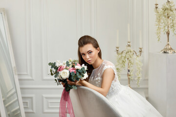 portrait of gorgeous beautiful tender young bride with flower bouquet in studio interior