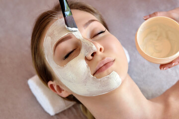 ace peeling mask, spa beauty treatment, skincare. Woman getting facial care by beautician at spa salon, close-up