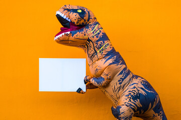 close up and portrait of a t-rex holding a white paper to write your text here - dinosaur holding a copy space