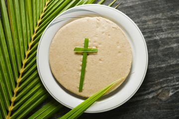 Pesaha Appam, Bread ,Paal religious Christian food on Maundy Thursday, Happy, Good Friday with rice flour Kerala India. Palm Sunday, Easter Sunday. Top view cross of coconut palm leaf background.