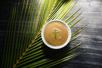 Pesaha Appam, Bread ,Paal religious Christian food on Maundy Thursday, Happy, Good Friday with rice flour Kerala India. Palm Sunday, Easter Sunday. Top view cross of coconut palm leaf background.
