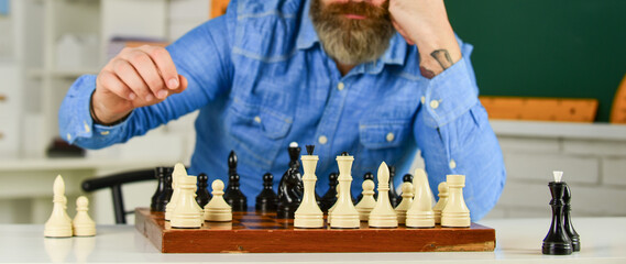 Figures on wooden chess board. Smart hipster man playing chess. Intellectual hobby. Thinking about...