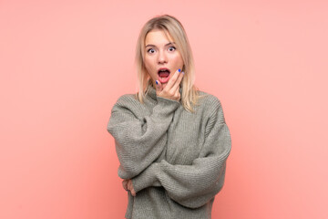 Young blonde Russian woman over isolated pink background surprised and shocked while looking right