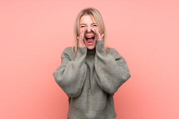 Young blonde Russian woman over isolated pink background shouting and announcing something