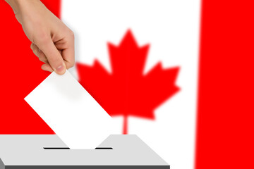 hand drops the ballot election against the background of the Canada flag, concept of state...