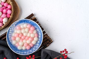 Top view of red and white tangyuan in blue bowl on white background for Winter solstice.