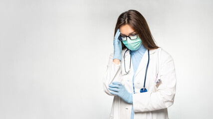 Overworked, sad and hopeless young female doctor in white coat, protective mask and gloves. Covid-19, coronavirus concept banner. Copy space for text