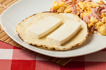 Arepa for breakfast, cheese and scrambled egg, a traditional Colombian dish.