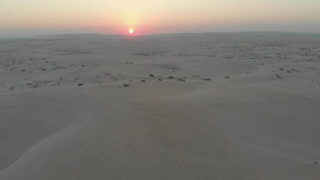 Aerial footage of cars dune bashing in the desert during sunset, eastern  Saudi Arabia 