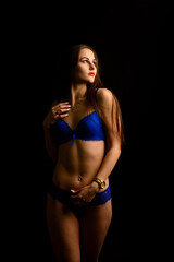 Beautiful sexy woman in blue underwear on dark background, perfect female body, studio shot