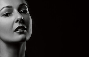 black and white portrait of beautiful woman isolated on dark background in studio shot