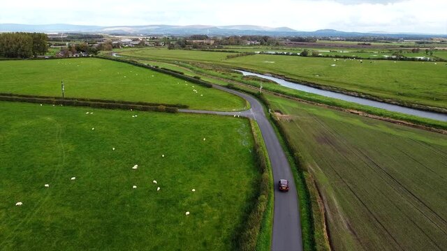 Aerial Overhead Drone Shot Tracking Car Driving Country Road by River (4K UHD)