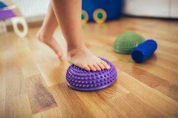 Flat feet correction exercise. Girl walking over spiked half balance massage balls