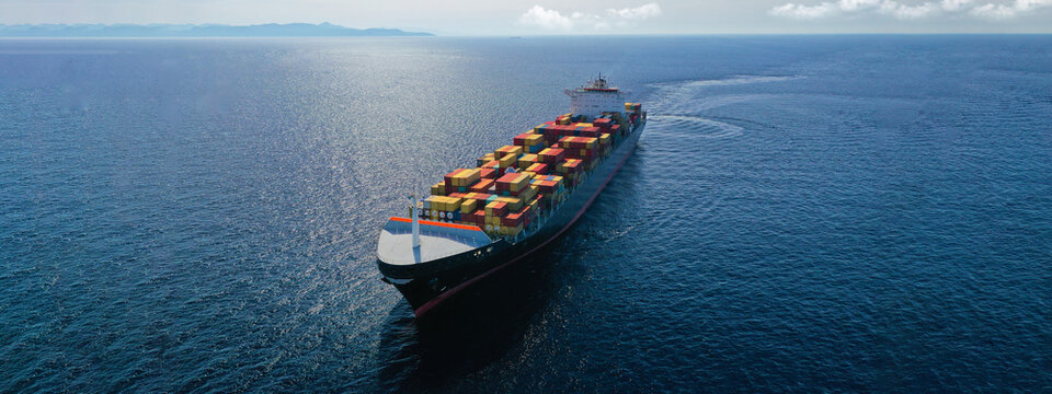 Aerial drone panoramic ultra wide photo of industrial truck size container tanker ship cruising in open ocean deep blue sea